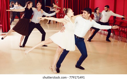 Group Of Happy People Dancing Samba In Couple In Dance Class
