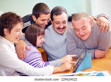 Group Of Happy People With Disability Having Fun With Tablet