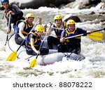 Group of happy people with guide whitewater rafting and rowing on river