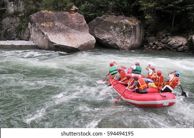 Group Of Happy People With Guide Whitewater Rafting And Rowing On River