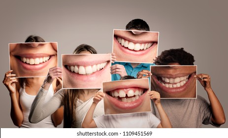 grupo de personas felices sosteniendo una foto de una boca sonriendo en un fondo gris