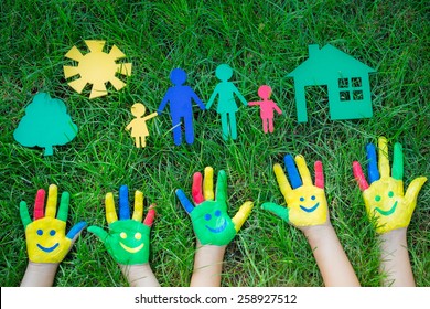 Group Of Happy People On Green Grass. Family Having Fun In Spring. Smiley On Hands. Ecology Concept. Top View Portrait