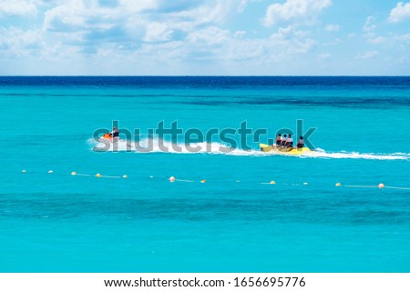 A Group of Happy People Riding Banana Boat Under Sunlight with Blue Sea Water in Background, Sharm El Sheikh, Sinai, Egypt