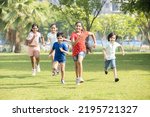Group of happy playful Indian children running outdoors in spring park. Asian kids Playing in garden. Summer holidays. 