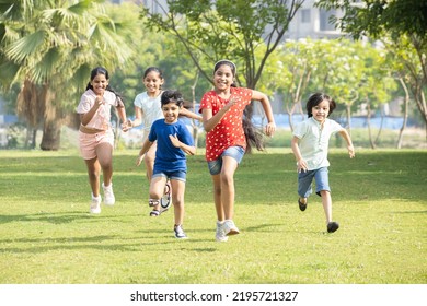 Group happy playful Indian children running outdoors in spring park  Asian kids Playing in garden  Summer holidays  