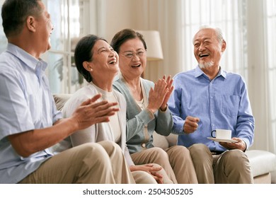 group of happy senior asian people sitting on couch at home having a pleasant conversation - Powered by Shutterstock