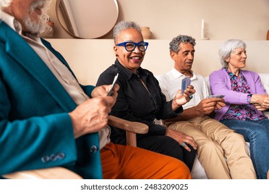 Group of happy senior friends bonding at home for dinner party - Cheerful and youthful old mature multiethnic people having fun - Powered by Shutterstock