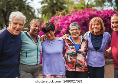 Group of happy senior friends smiling in front of camera after sport workout at city park - Fit elderly people hugging each other outdoor - Powered by Shutterstock