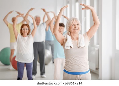 Group of happy seniors during warm-up before exercise - Powered by Shutterstock