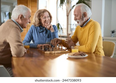 Group of happy seniors talking while playing chess  at home. - Powered by Shutterstock