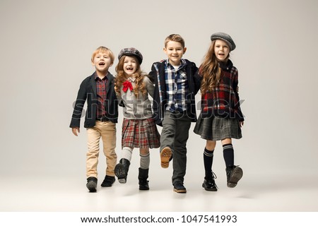 The group of happy smiling teen girls and boys. Sublings day. Stylish young teen girls posing at studio. Classic autumn style. Teen and kids fashion concept. children's fasion concept