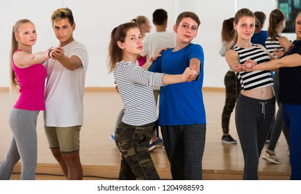 Group Of Happy Teen Learning To Dancing Tango In Dance Studio