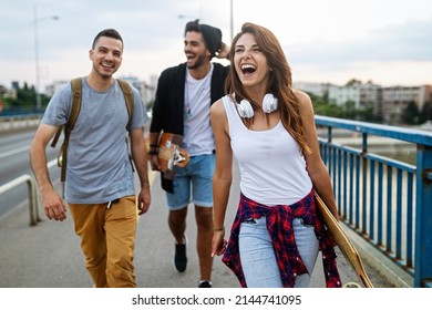 Group of happy teen people hang out together and enjoying skateboard outdoors. - Powered by Shutterstock