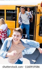 Group Of Happy Teen Scholars Running At School From Bus