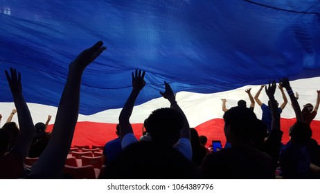 Group Of Happy Thailand Soccer Fans Silhouette At Stadium,cheer By Doing The Waves With National Flag.