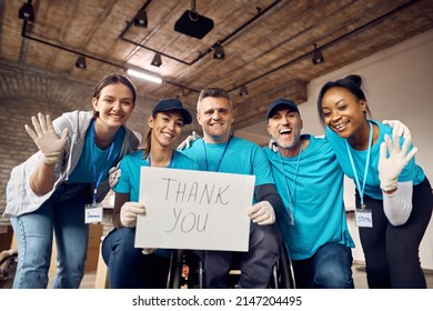 Group of happy volunteers holding placard with 'thank you' message while working at donation center.  - Powered by Shutterstock