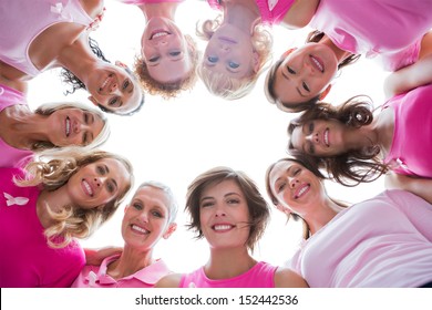 Group of happy women in circle wearing pink for breast cancer on white background - Powered by Shutterstock