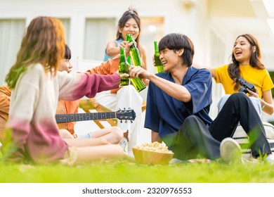 Group of Happy young Asian man and woman friends enjoy and fun reunion meeting party at home backyard with playing guitar, singing, eating food and drinking beer together on summer holiday vacation. - Powered by Shutterstock