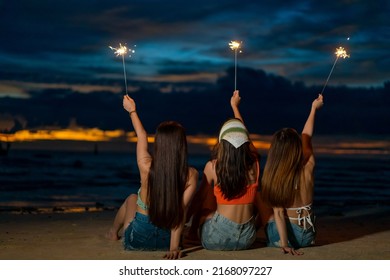 Group of Happy young Asian woman sitting and playing sparklers together on tropical island beach at summer night. Smiling female friends enjoy and fun outdoor lifestyle on holiday travel vacation trip - Powered by Shutterstock