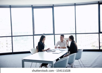 Gruppe glücklicher junger Geschäftsleute in einer Sitzung im Büro