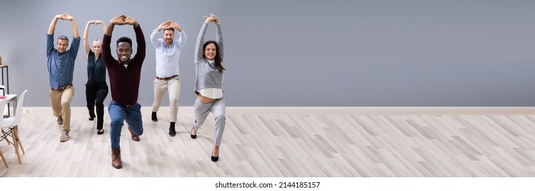 Group Of Happy Young Businesspeople Doing Stretching Exercise In Office