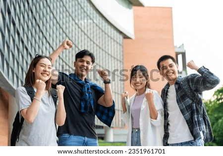 Group of happy young entrepreneurs with hands up and laughing to celebrate and excited success for achievements obtained. Undergraduate students celebrate success after end project, teamwork concept