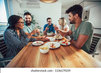 Group Of Happy Young Friends Enjoying Dinner At Home. Group of multiethnic friends enjoying dinner party