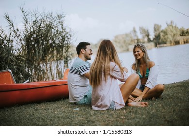 Group of happy young friends enjoying the nature on the lakeside