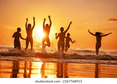 Group of happy young friends are having fun and runs to sunset sea beach over the waves - Powered by Shutterstock