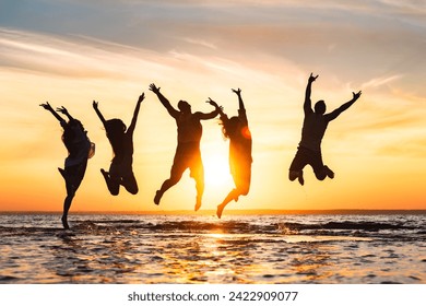 Group of happy young friends are having fun and jumping at calm sunset beach - Powered by Shutterstock