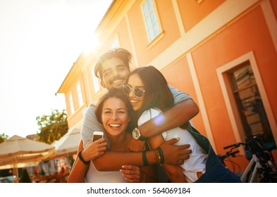 Group Of Happy Young Friends Having Fun On City Street.Sunset.