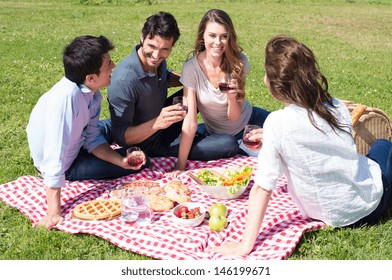 Group Of Happy Young Friends On Vacation Enjoying Wine At Picnic