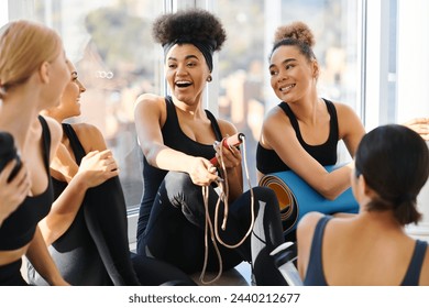 group of happy young interracial women in active wear chatting after workout in pilates studio - Powered by Shutterstock