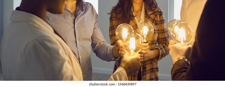 Group of happy young multiracial business people holding electric light bulbs. Team of colleagues join Edison light bulbs as conceptual metaphor for teamwork and sharing ideas in creative community - Powered by Shutterstock