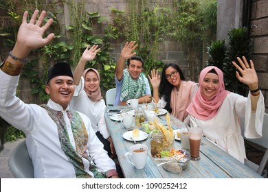 Group Happy Young Muslim Waving At Table Dining During Ramadan Celebration