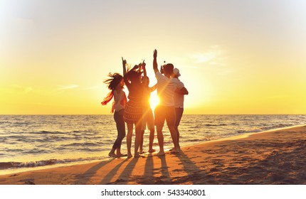 Group Of Happy Young People Dancing At The Beach On Beautiful Summer Sunset