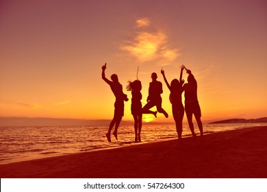 Group Of Happy Young People Dancing At The Beach On Beautiful Summer Sunset