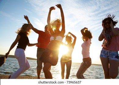 group of happy young people dancing at the beach on  beautiful summer sunset - Powered by Shutterstock