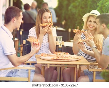 Group Of Happy Young People Eating Pizza In A Restaurant