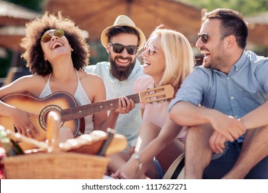 Group Of Happy Young People Having A Picnic On The Beach,having Fun Together.