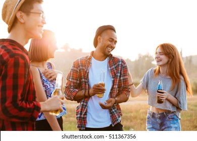 Group Of Happy Young People Laughing And Drinking Beer And Soda Outdoors