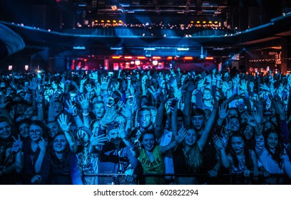 Group Of Happy Young People On Rap Concert In Night Club. Crowded Dancefloor With Excited Music Fans. Musical Festival Audience On Entertainment Event In Bright Blue Stage Light EUROPE-11 OCTOBER,2022