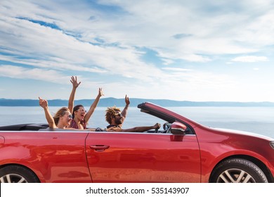 Group of happy young people waving from the red convertible. - Powered by Shutterstock