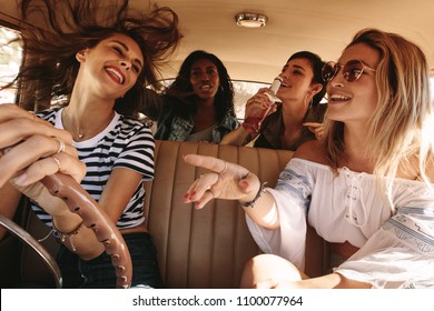 Group Of Happy Young Women Laughing And Enjoying In Car During A Road Trip To Vacation. Girls Having Fun On Road Trip.