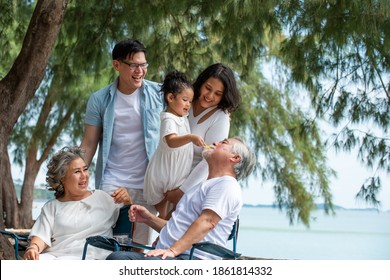 Group Of Healthy Multi Generation Asian Family Enjoy Picnic Travel Together On The Beach. Parents With Cute Child Girl And Healthy Senior Grandparents Relax And Having Fun On Summer Holiday Vacation
