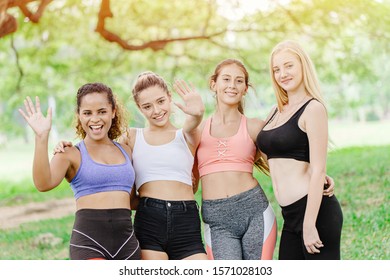 Group Of Healthy Sport Women Friend Together Hi Five Hand Greeting Looking Camera At Outdoor Green Park For Meeting Workout Together.