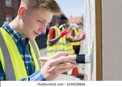 Group Of Helpful Teenagers Creating And Maintaining Community Art Project