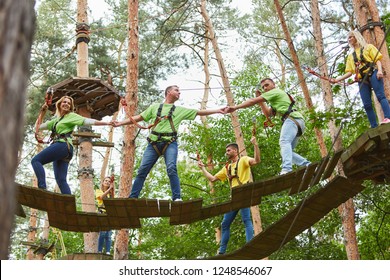 Group helps with climbing in high wire garden as a team training activity