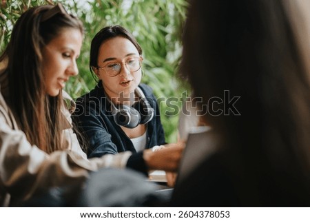 A group of high school friends study together in a cozy coffee shop. They collaborate on assignments, showcasing teamwork and friendship in a relaxed setting. Perfect for education and social themes.