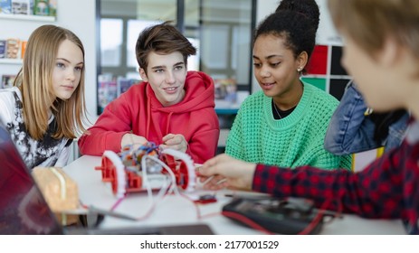 Group Of High School Students Building And Programming Electric Toys And Robots At Robotics Classroom